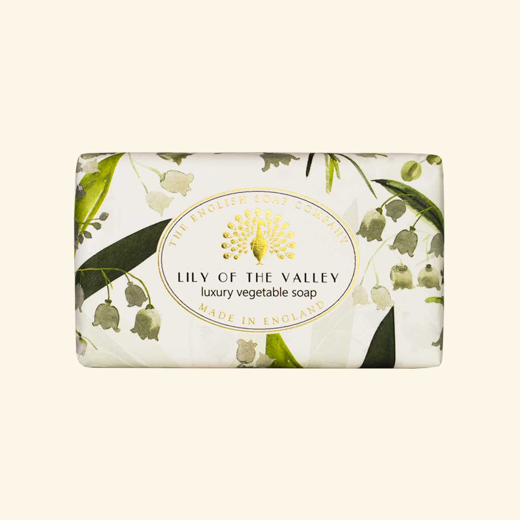 “Seife mit zartem Maiglöckchen-Muster in Grün-Weiß und Aufschrift ‘Lily of the Valley – luxury vegetable soap’.”