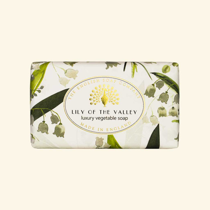 “Seife mit zartem Maiglöckchen-Muster in Grün-Weiß und Aufschrift ‘Lily of the Valley – luxury vegetable soap’.”