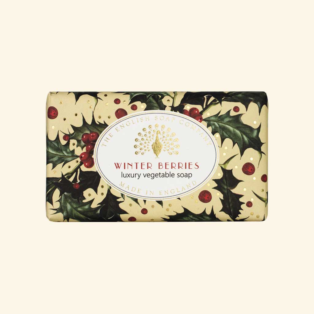 “Cremefarbene Seife mit Stechpalmen- und Beerenmotiv, Aufschrift ‘Winter Berries – luxury vegetable soap’.”
