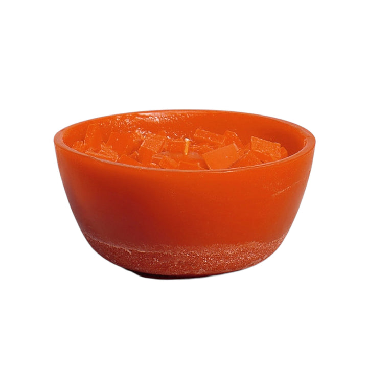 Orangefarbene Schalenkerze mit groben Wachsbrocken an der Oberfläche, freigestellt auf weißem Hintergrund.