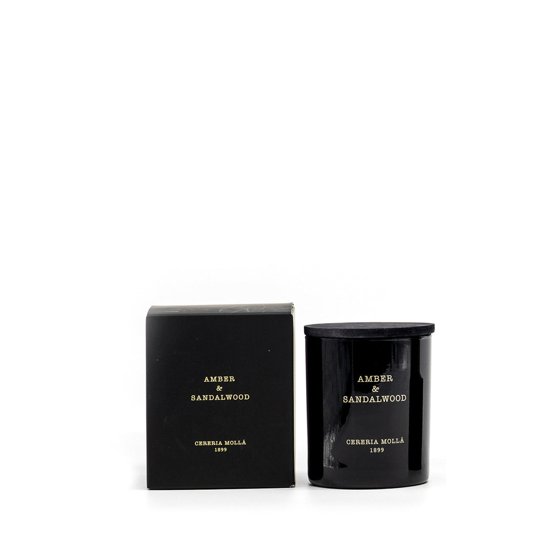 Duftkerze Amber & Sandalwood von Cereria Mollá im schwarzen Glas mit passender, mattschwarzer Geschenkbox. Minimalistisches Design vor weißem Hintergrund – edel und zeitlos