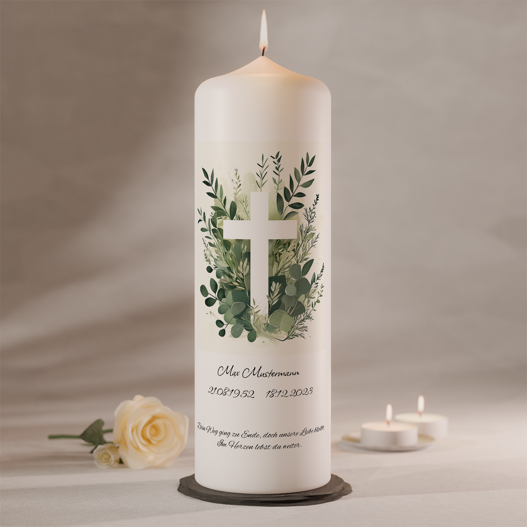 Trauerkerze mit Kreuz und Eukalyptuszweigen als Symbol für Glauben, Hoffnung und Erinnerung