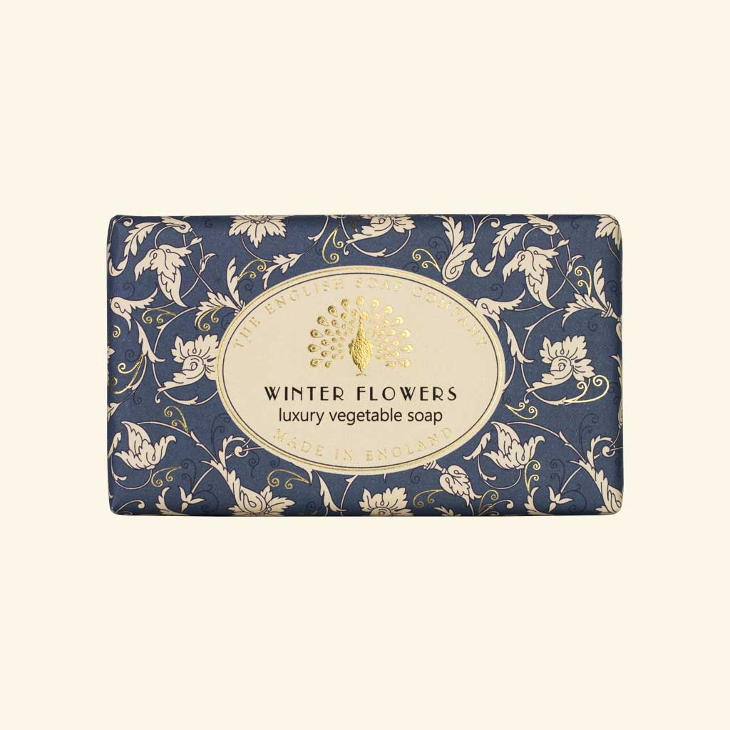 “Blaue Seife mit cremefarbenem Blumenmuster und Aufschrift ‘Winter Flowers – luxury vegetable soap’.”