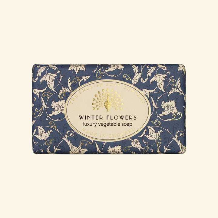 “Blaue Seife mit floralem Muster in Weiß und Aufschrift ‘Winter Flowers – luxury vegetable soap’.”