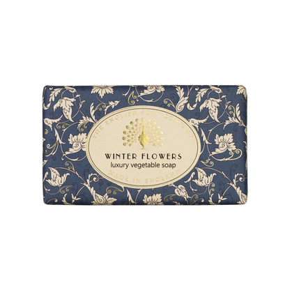 “Blaue Seife mit cremefarbenem Blumenmuster und Aufschrift ‘Winter Flowers – luxury vegetable soap’.”