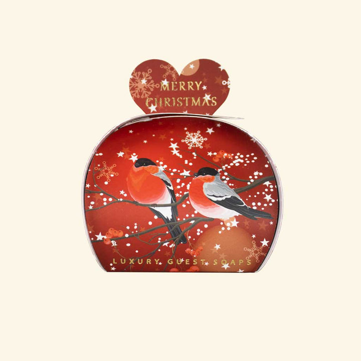 „Weihnachtsseife der Marke The English Soap Company in herzförmiger Geschenkverpackung, Motiv: zwei Rotkehlchen auf einem Zweig vor rotem Hintergrund mit Schneeflocken, Aufschrift: ‚Merry Christmas‘ und ‚Luxury Guest Soaps‘.“