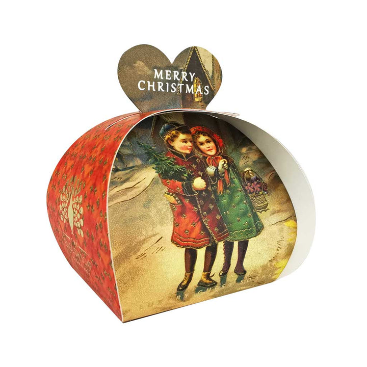 „Weihnachtsseife der Marke The English Soap Company in herzförmiger Geschenkverpackung mit rotem Seitenmotiv, Motiv: zwei Kinder mit Weihnachtsbaum im Vintage-Stil vor winterlicher Landschaft, Aufschrift: ‚Merry Christmas‘.“