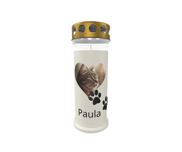 Weiße Gedenkkerze mit goldenem Deckel vor weißem Hintergrund. Auf der Kerze befindet sich ein herzförmiges Bild einer grau-getigerten Katze, darunter zwei schwarze Pfotenabdrücke. Der Name „Paula“ ist in klarer schwarzer Schrift darunter platziert. Das Design vermittelt liebevolle Erinnerung an ein verstorbenes Haustier.