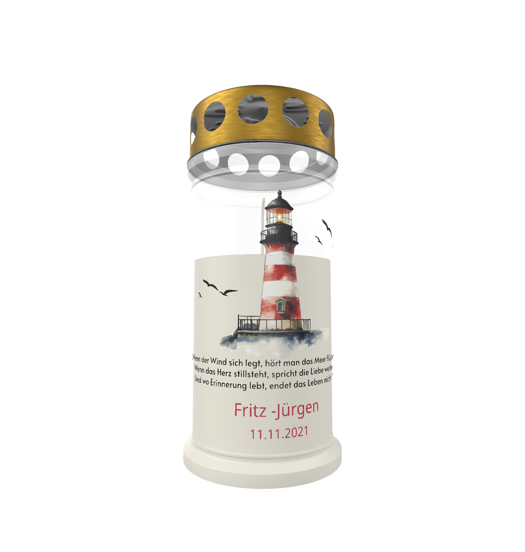 Weiße Gedenkkerze mit goldenem Deckel und maritimem Motiv vor weißem Hintergrund. Auf der Kerze ist ein rot-weiß gestreifter Leuchtturm abgebildet, umgeben von fliegenden Möwen. Darunter steht ein Gedenkspruch in feiner Schrift. In Rot hervorgehoben sind der Name „Fritz - Jürgen“ und das Datum „11.11.2021“.