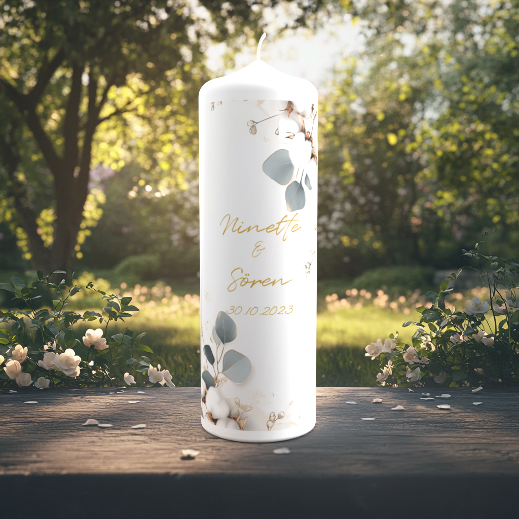Eine edle Hochzeitskerze steht auf einem Holztisch im Garten, umgeben von weiß blühenden Rosen und sanftem Sonnenlicht. Die Kerze ist verziert mit zarten botanischen Elementen: Eukalyptusblättern, Baumwollblüten und feinen goldenen Akzenten. In der Mitte stehen die Namen „Ninette & Sören“ in goldener Schreibschrift sowie das Hochzeitsdatum „30.10.2023“. Das Design ist dezent, natürlich und elegant.