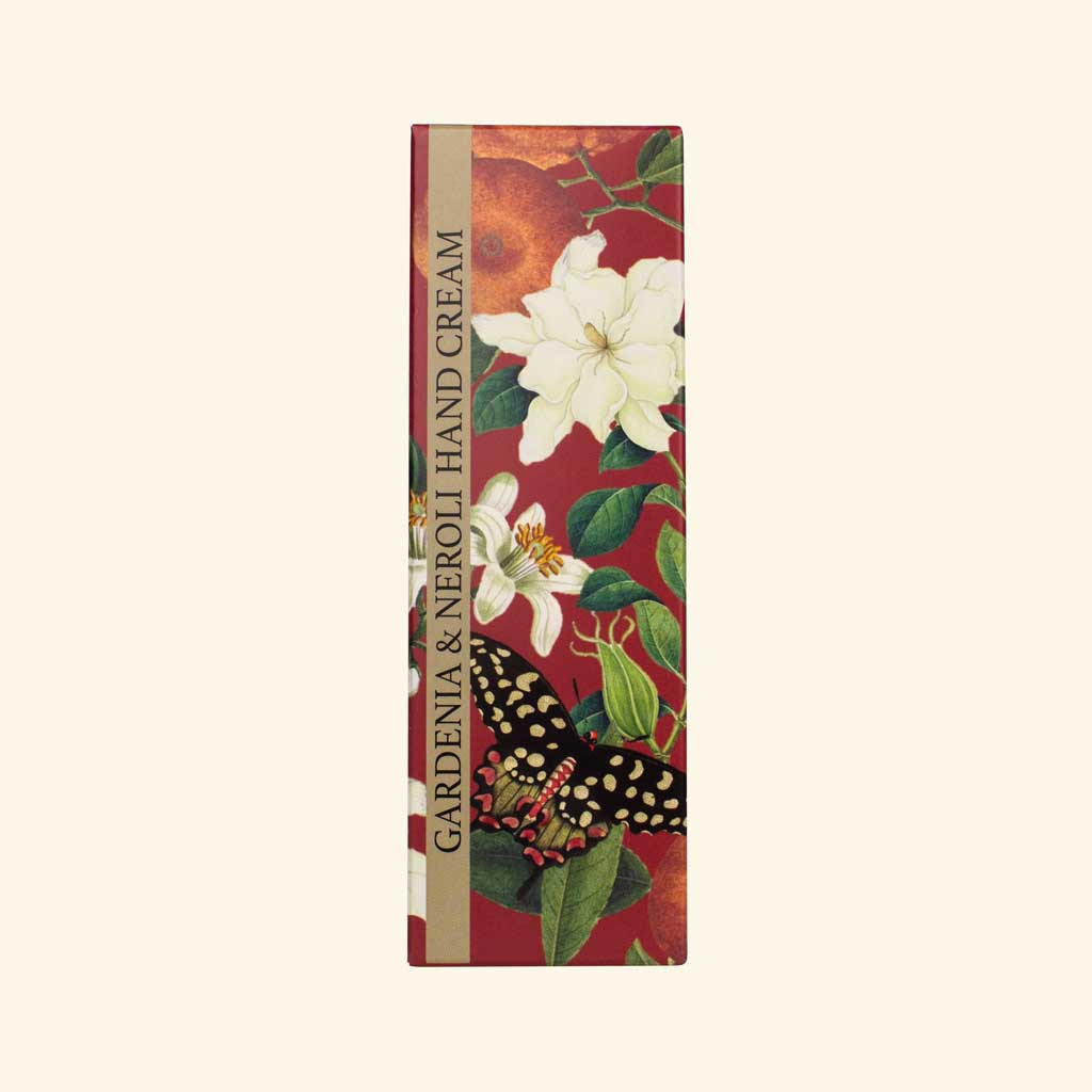 „Verpackung der Handcreme mit Gardenie und Neroli, verziert mit floralen Motiven und Schmetterling auf rotem Hintergrund.“