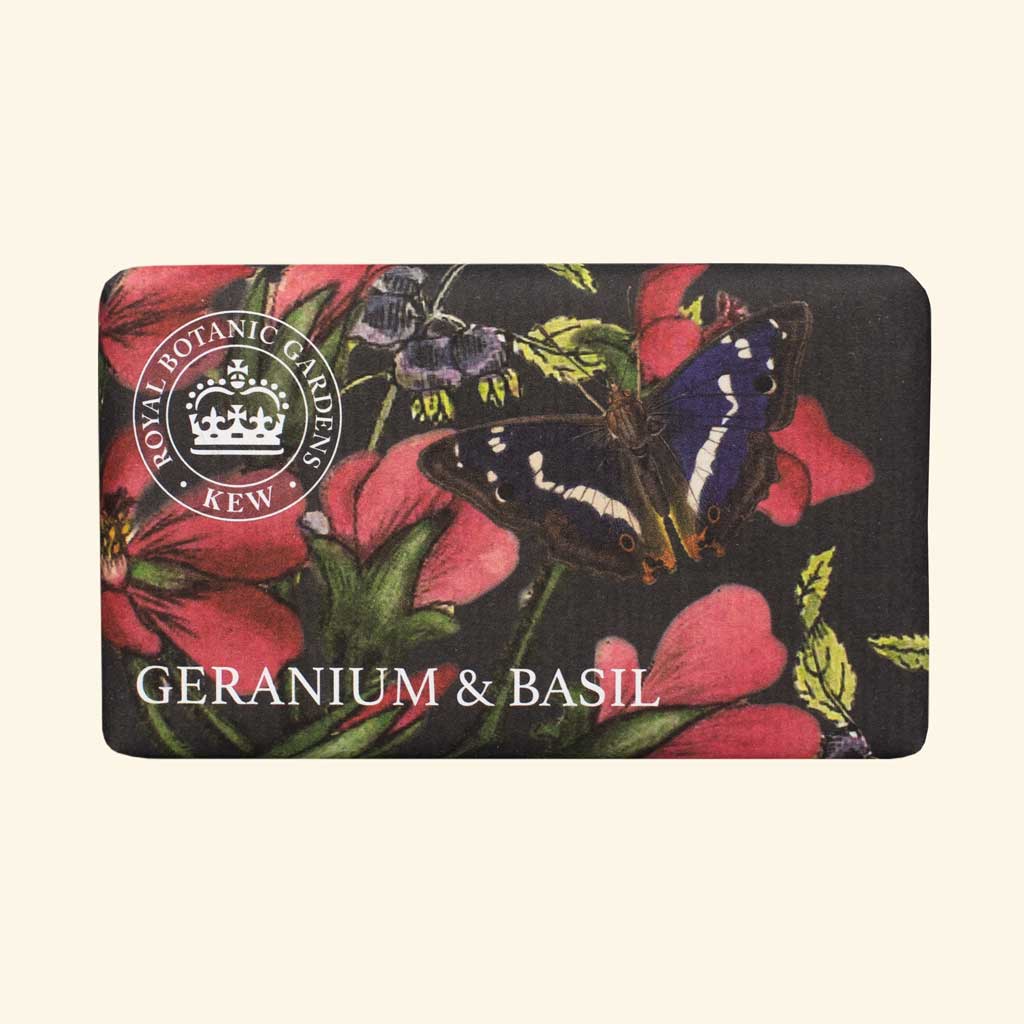 “Seifendose mit floralen Motiven in Rot und Grün, Schmetterlingen und der Aufschrift: Geranium & Basil.”