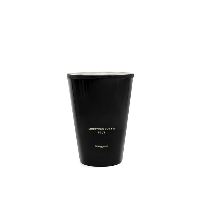 Große, schwarze Duftkerze Mediterranean Blue von Cereria Mollá im schlichten, glänzenden Glas mit goldener Aufschrift. Fotografiert vor weißem Hintergrund – elegant, modern und maritim inspiriert
