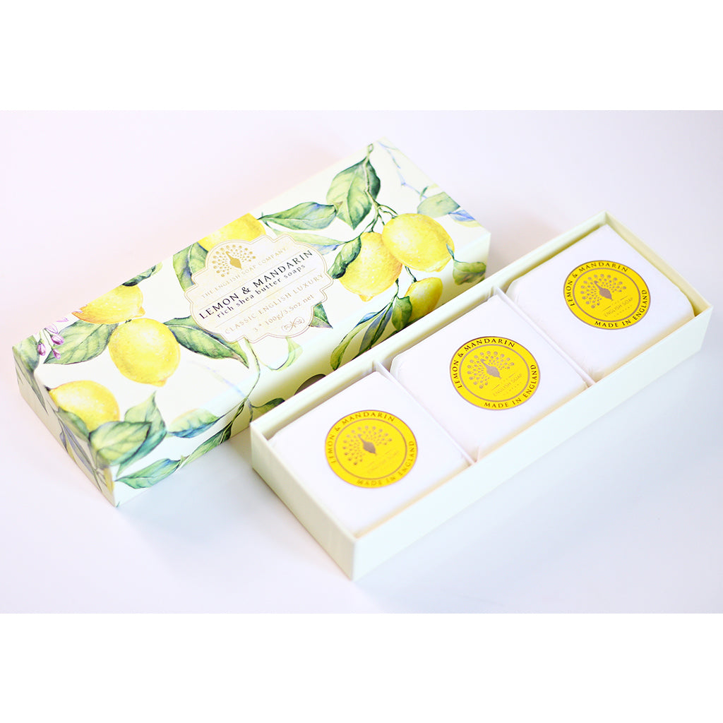„Geöffnete Geschenkbox mit drei runden Seifen der Sorte ‘Lemon & Mandarin’, in hell dekorierter Verpackung mit Zitronenmotiv auf weißem Hintergrund.“