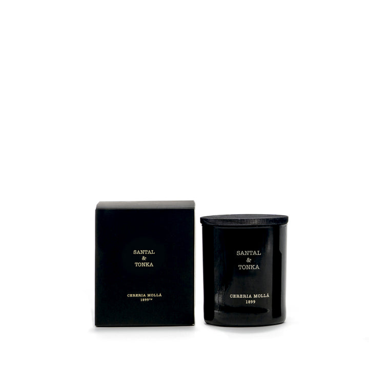 Schwarze Duftkerze SANTAL & TONKA von Cereria Mollá neben passender schwarzer Produktverpackung mit goldener Schrift. Fotografiert vor weißem Hintergrund – edel, minimalistisch und hochwertig inszeniert.