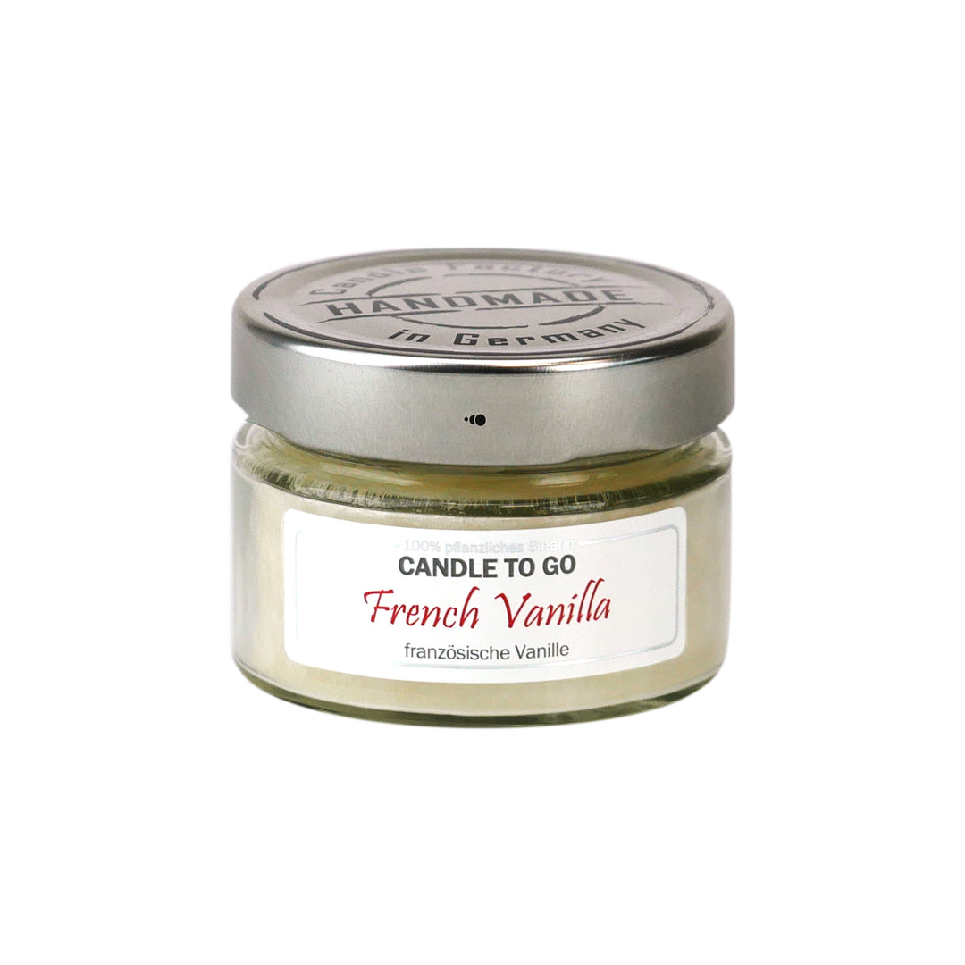 Kleine weiße Duftkerze im Glas mit Metalldeckel und Etikett „Candle to go – French Vanilla“ auf weißem Hintergrund.