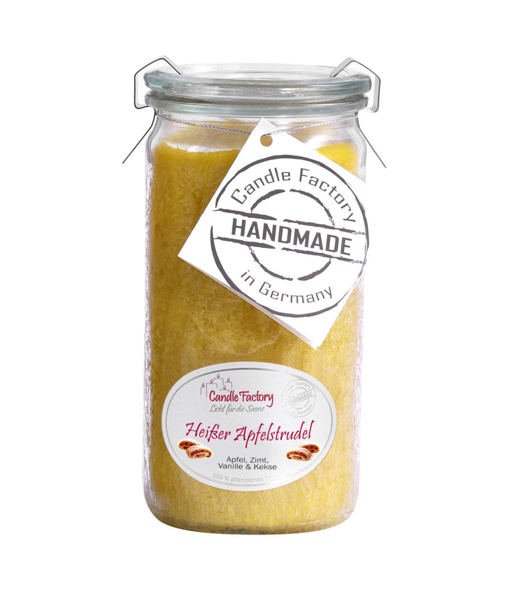 Gelbe Duftkerze im hohen Glas mit Etiketten „Heißer Apfelstrudel“ und „Handmade in Germany“ auf weißem Hintergrund.