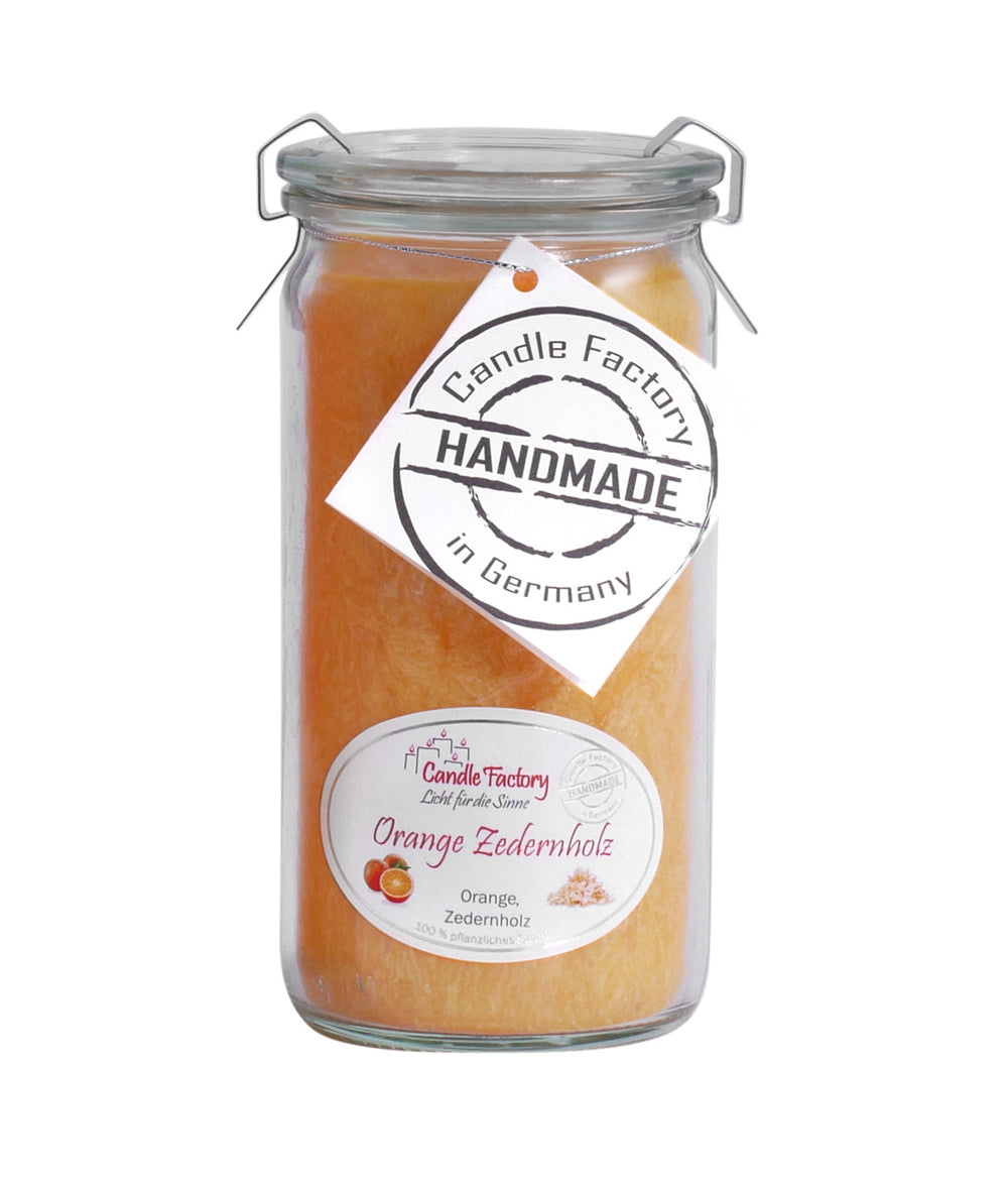 Orange Duftkerze im hohen Glas mit Etiketten „Orange Zedernholz“ und „Handmade in Germany“ auf weißem Hintergrund.