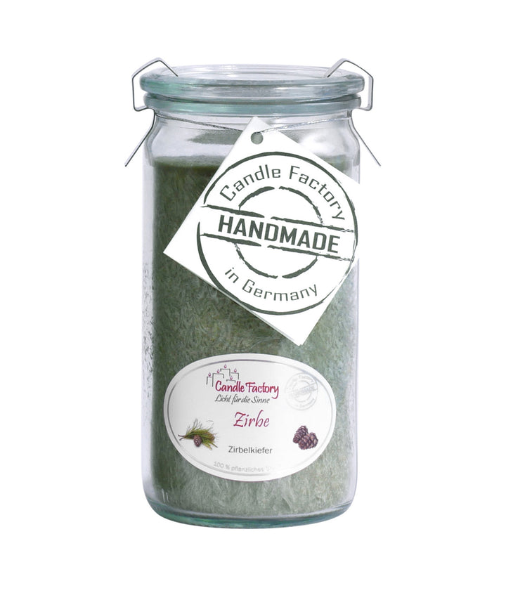 Grüne Duftkerze im hohen Glas mit Etiketten „Zirbe“ und „Handmade in Germany“ auf weißem Hintergrund.
