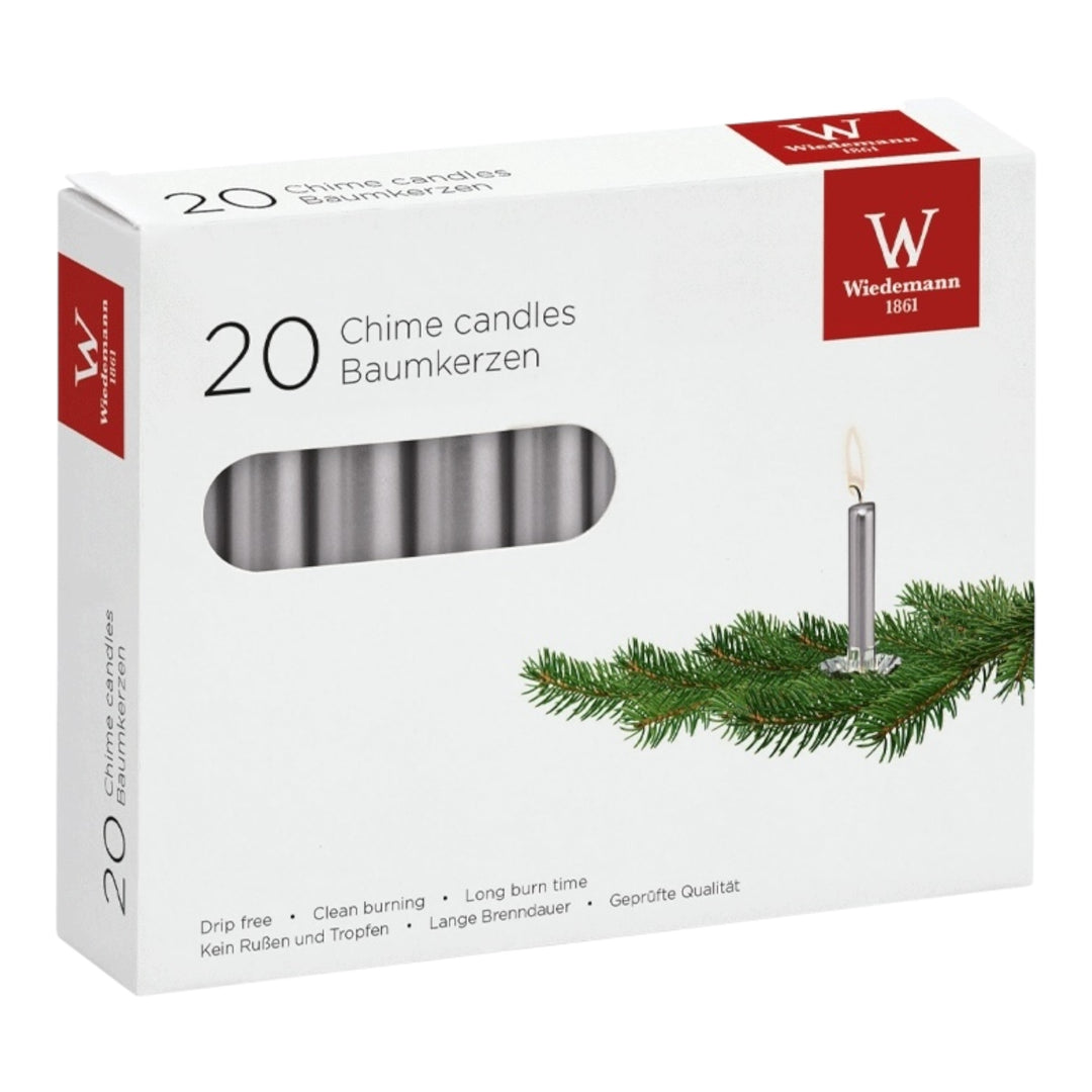 Verpackung mit 20 silberfarbenen Christbaumkerzen, daneben Tannenzweig-Deko