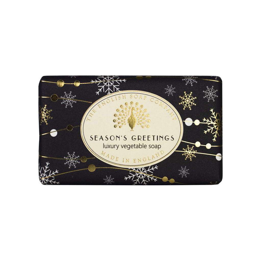 Schwarze Seife mit goldenen und weißen Schneeflocken, Aufschrift „Season’s Greetings – Luxury Vegetable Soap“ von The English Soap Company.