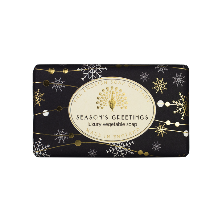 Schwarze Seife mit goldenen und weißen Schneeflocken, Aufschrift „Season’s Greetings – Luxury Vegetable Soap“ von The English Soap Company.