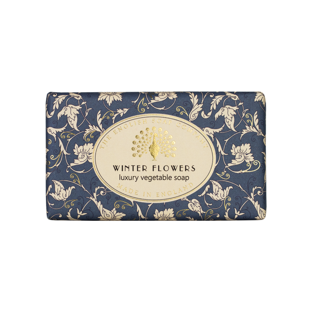 Blaue Seife mit weißem floralen Muster und goldfarbenem Etikett mit der Aufschrift „Winter Flowers – luxury vegetable soap“.