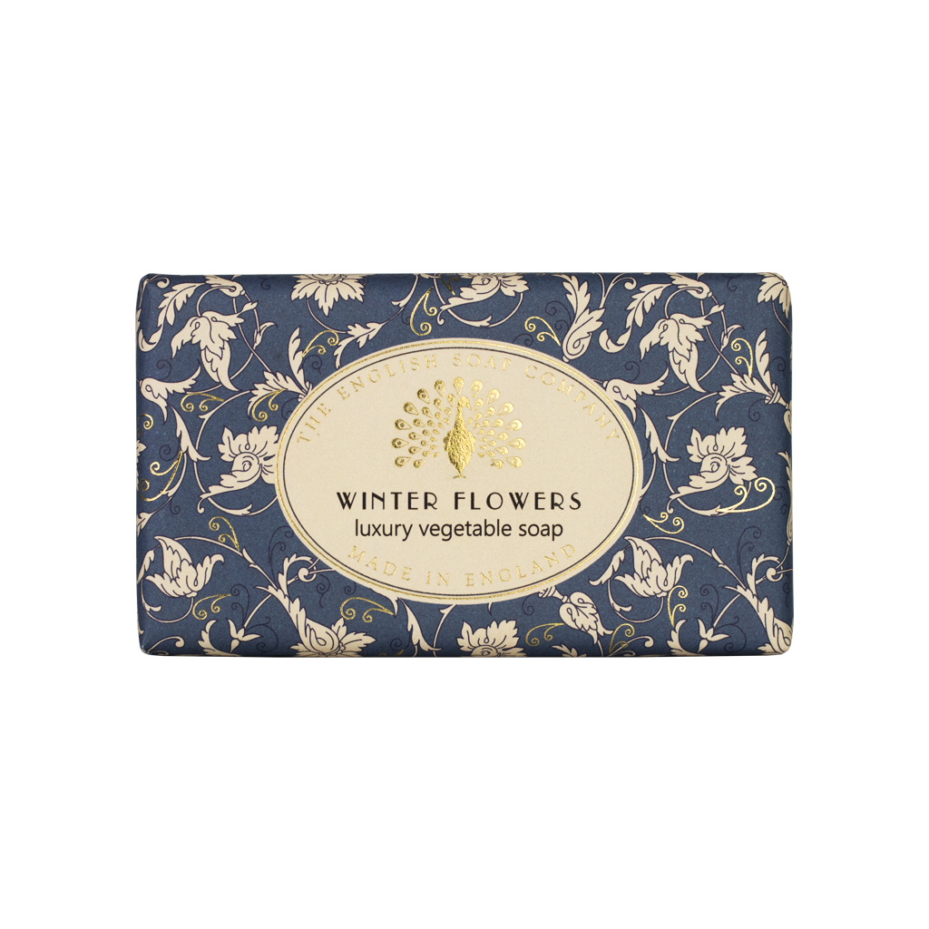 Blaue Seife mit weißem floralen Muster und goldfarbenem Etikett mit der Aufschrift „Winter Flowers – luxury vegetable soap“.