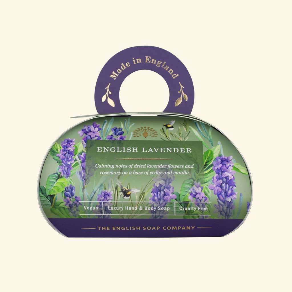 Luxus-Hand- und Körperseife der Marke The English Soap Company in ovaler Verpackung mit Tragegriff, Lavendelblüten, Kräutern und Bienen auf hellem Hintergrund, Aufschrift English Lavender.