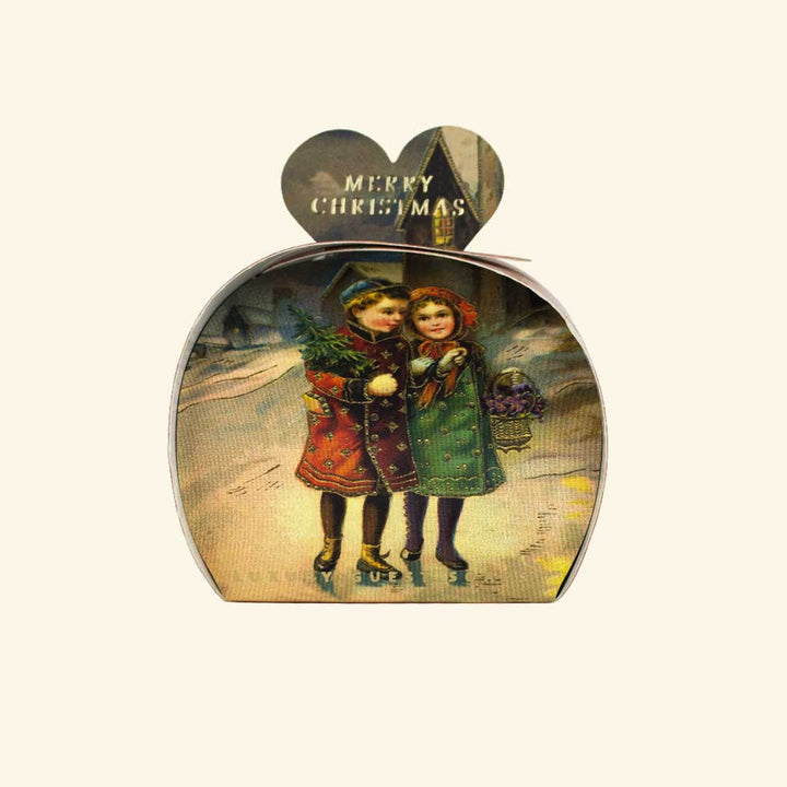 Weihnachtsseife der Marke The English Soap Company in herzförmiger Geschenkverpackung, Motiv mit zwei Kindern in Winterkleidung vor verschneiter Kulisse, Aufschrift Merry Christmas.