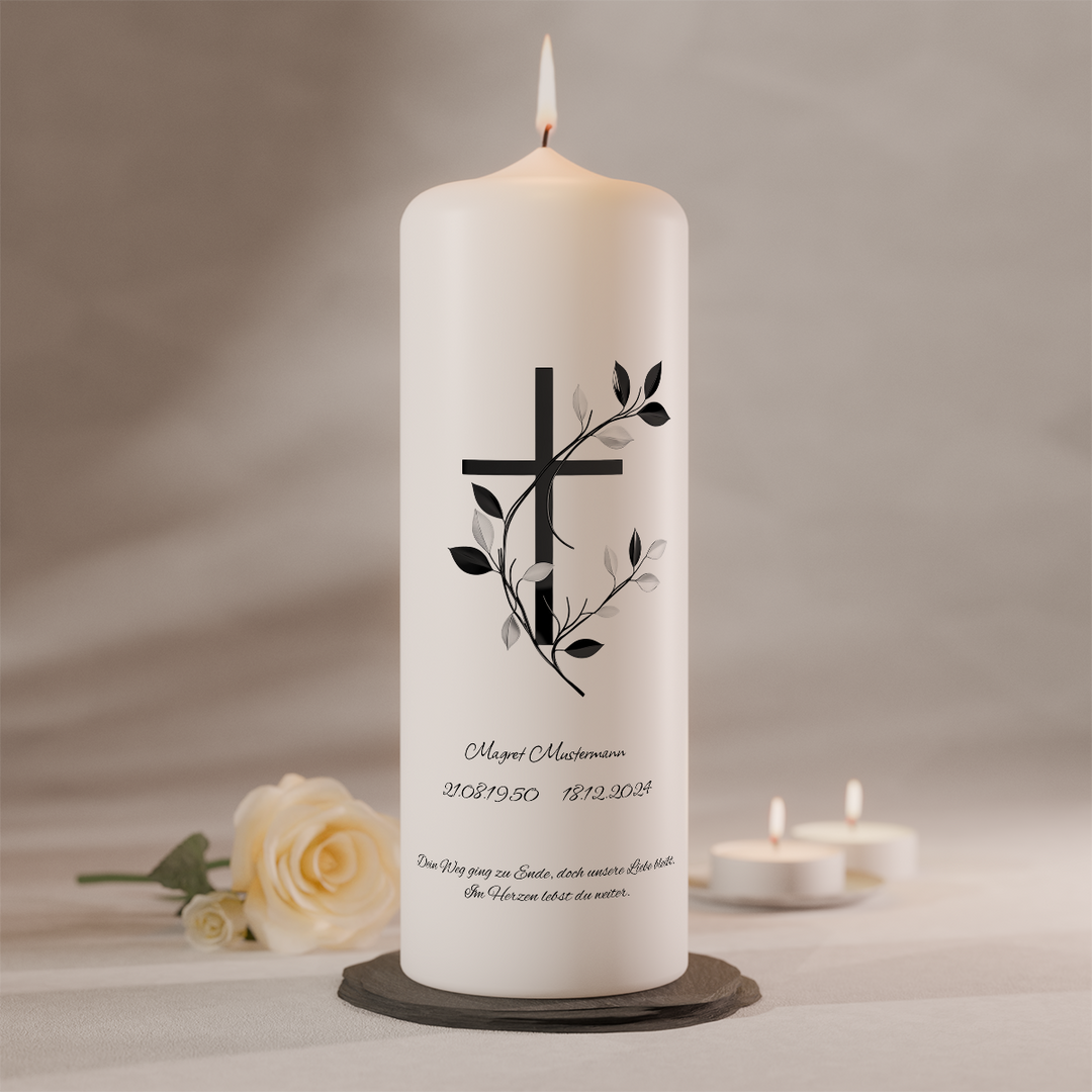 Personalisierbare Gedenkkerze mit Kreuzmotiv und dekorativer Ranke auf weißer Trauerkerze