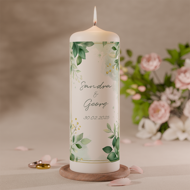 personalisierte hochzeitskerze mit gruenem blattdesign und namen des brautpaares auf weisser stumpenkerze