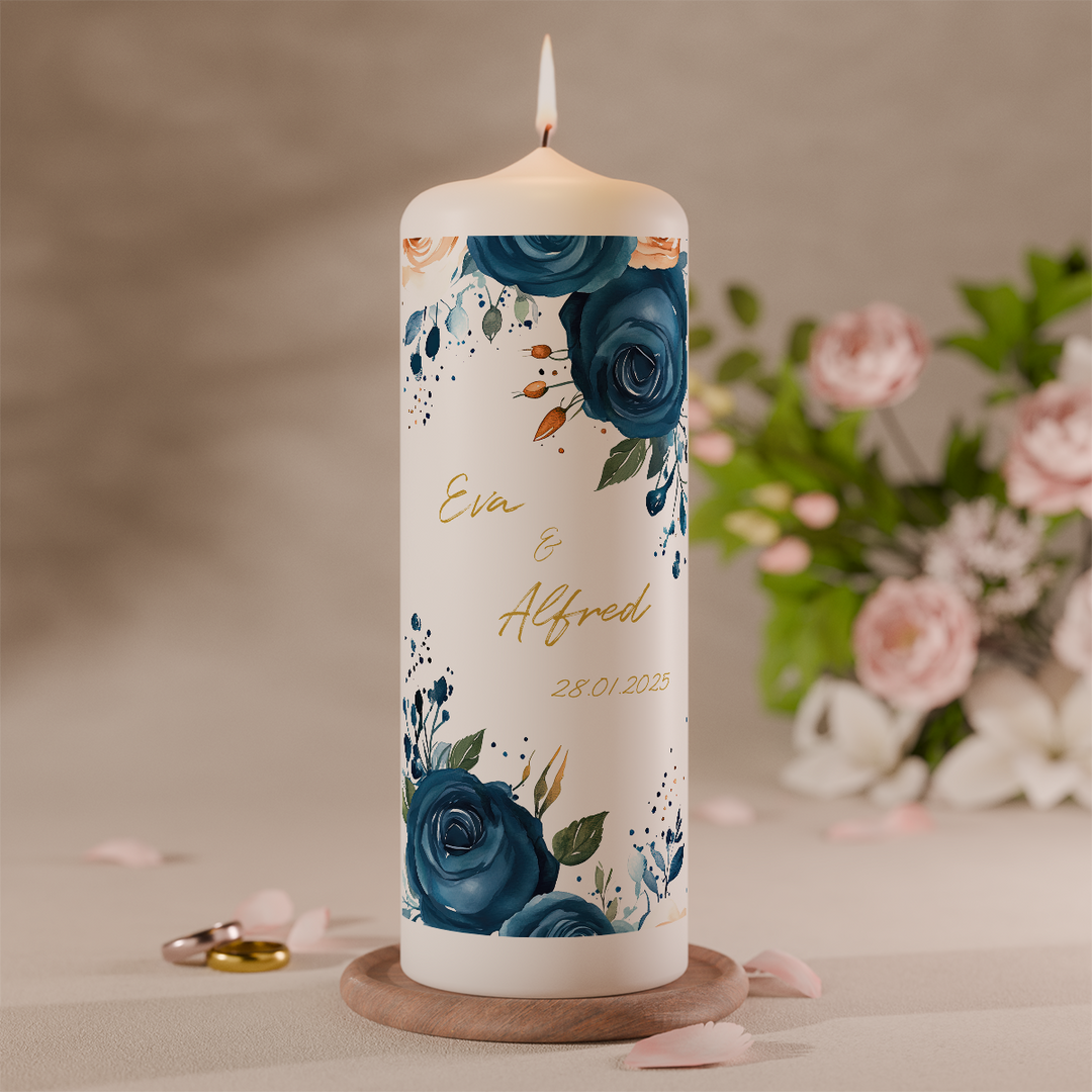 Hochzeitskerze mit blauen Blüten und goldenen Details personalisiert mit Namen und Datum vor Blumen