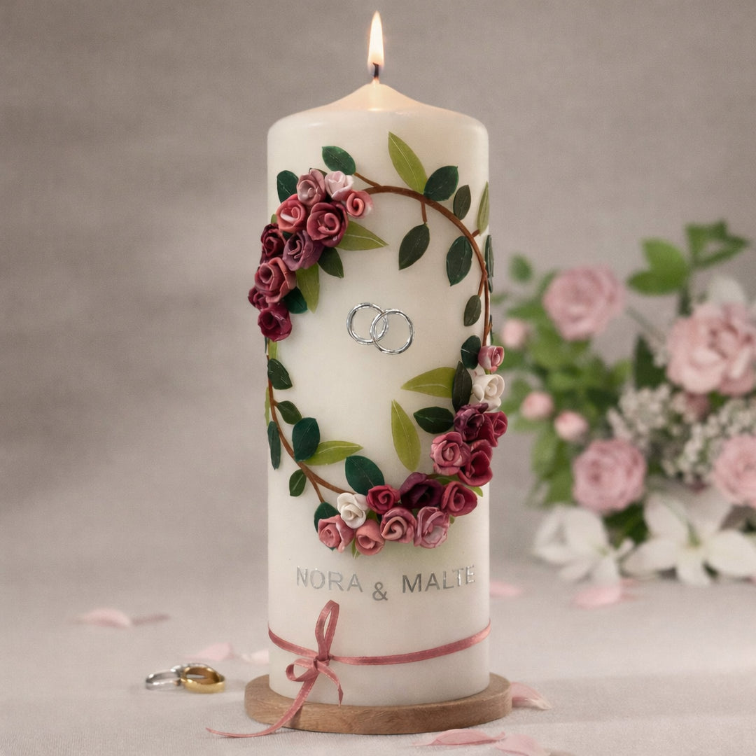 Hochzeitskerze mit rosafarbenem Blütenkranz und silbernen Eheringen, personalisierbar mit Namen und Datum