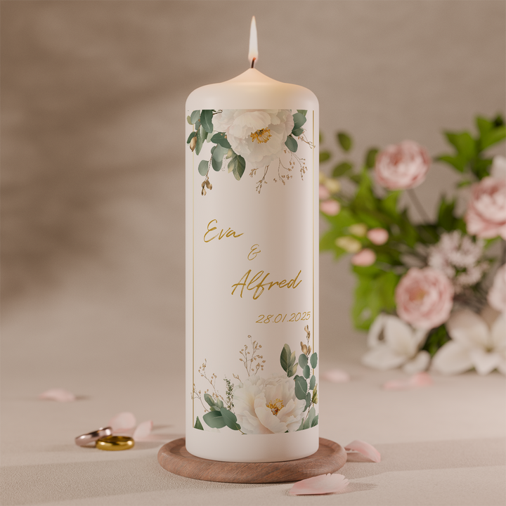 Hochzeitskerze mit feinem Blätter- und Blumenmotiv in Grün personalisiert mit Namen und Datum vor Blumen