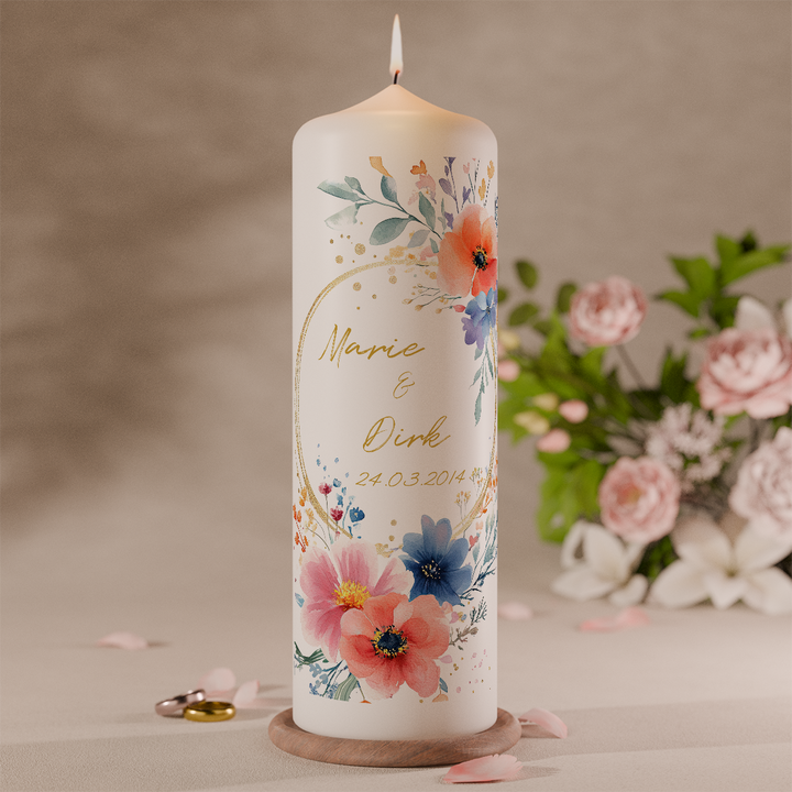Bunte Hochzeitskerze mit Aquarellblumen in Pink, Blau und Orange personalisiert mit Namen und Datum vor Blumen