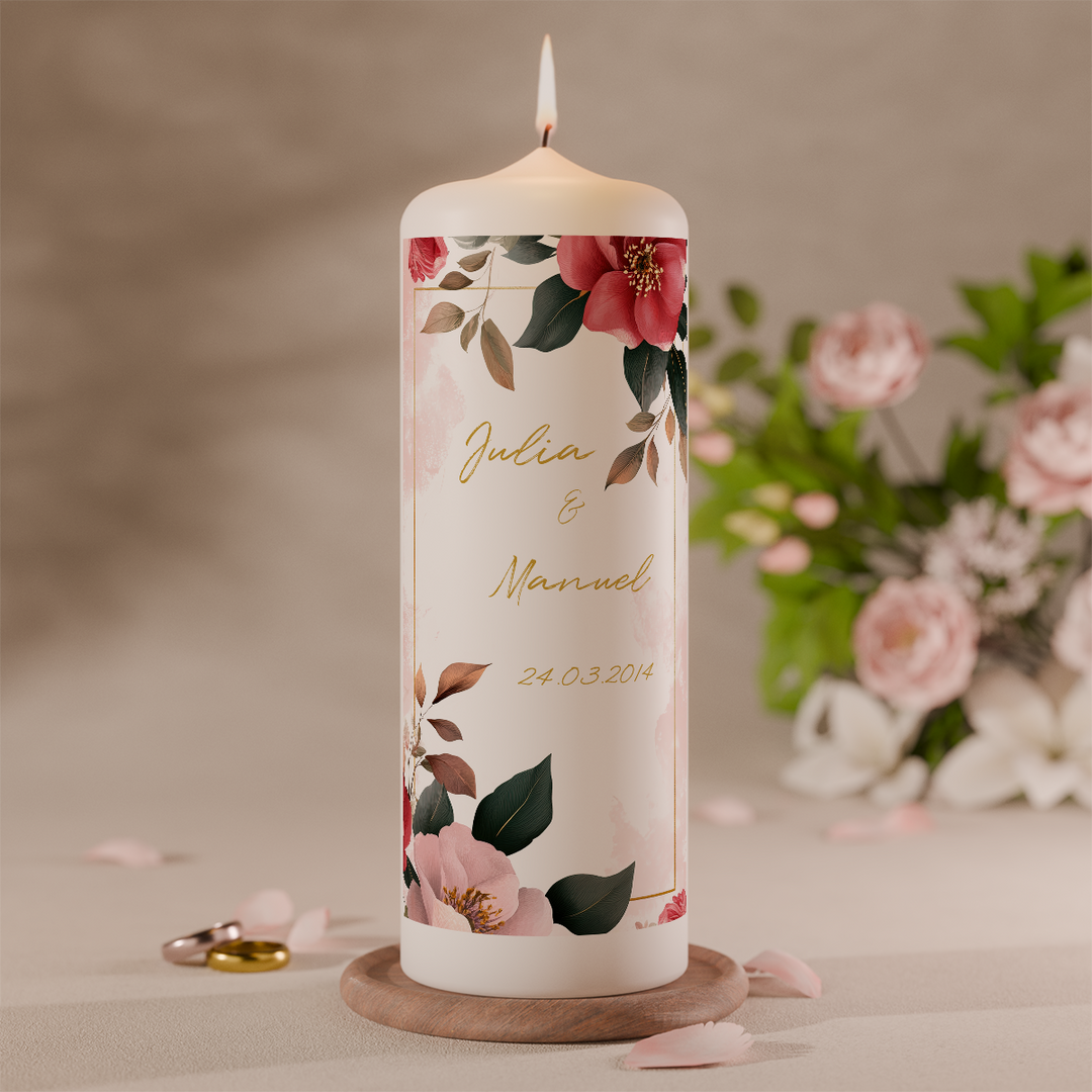 Klassische Hochzeitskerze mit Kamelienblüten in warmen Farben personalisiert mit Namen und Datum vor Blumen