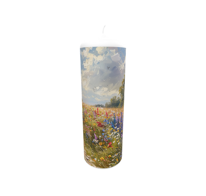 Künstlerkerze mit floraler Szene in Gold und Flammenspiel vor hellem Himmel