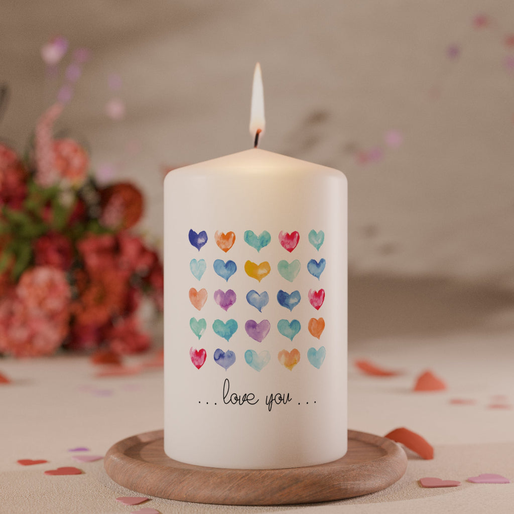 Weiße Kerze mit bunten Aquarell-Herzmotiven in Reihen und Schriftzug love you als liebevolle Geschenkkerze