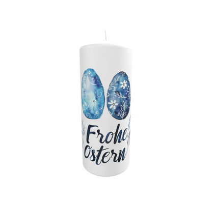 Weiße Osterkerze mit zwei blau verzierten Ostereiern und dem Schriftzug „Frohe Ostern“ in moderner Handschrift