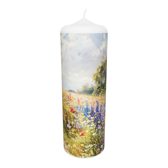 Künstlerkerze mit floraler Szene in Gold und Flammenspiel vor hellem Himmel