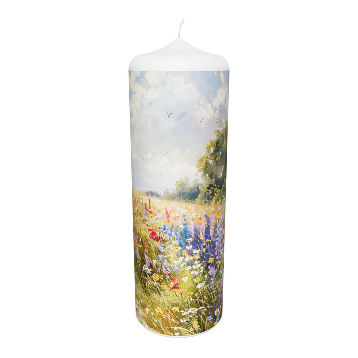 Künstlerkerze mit floraler Szene in Gold und Flammenspiel vor hellem Himmel