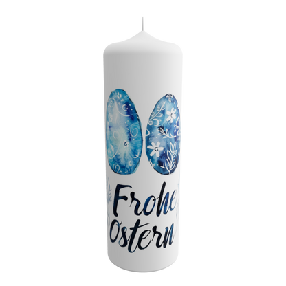 Weiße Osterkerze mit zwei blau verzierten Ostereiern und dem Schriftzug „Frohe Ostern“ in moderner Handschrift
