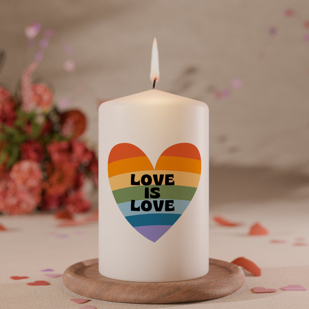 Weiße Kerze mit Herzmotiv in Regenbogenfarben und Schriftzug Love is Love als Symbol für Vielfalt und Liebe