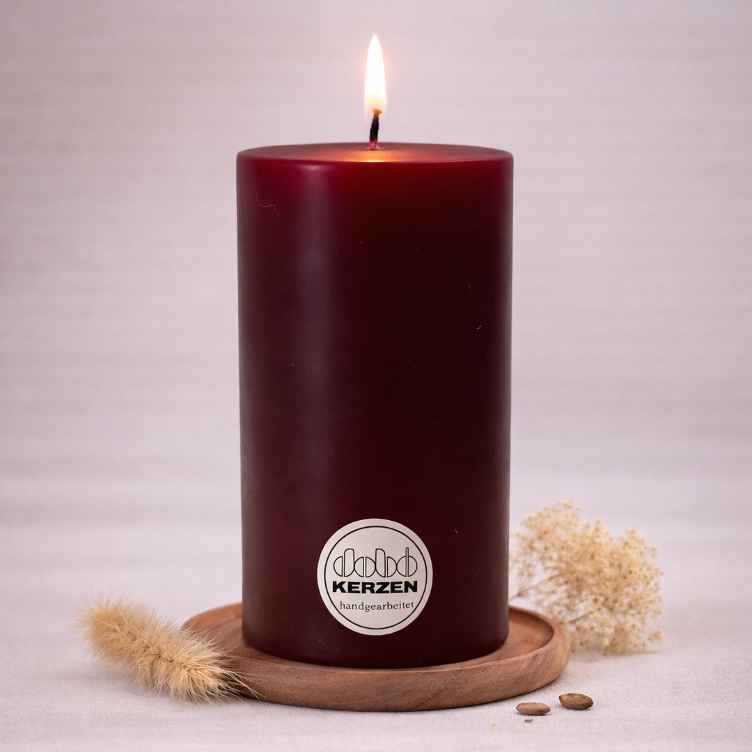 bordeaux stumpenkerze handgefertigt dobo kerze brennend auf holzuntersetzer