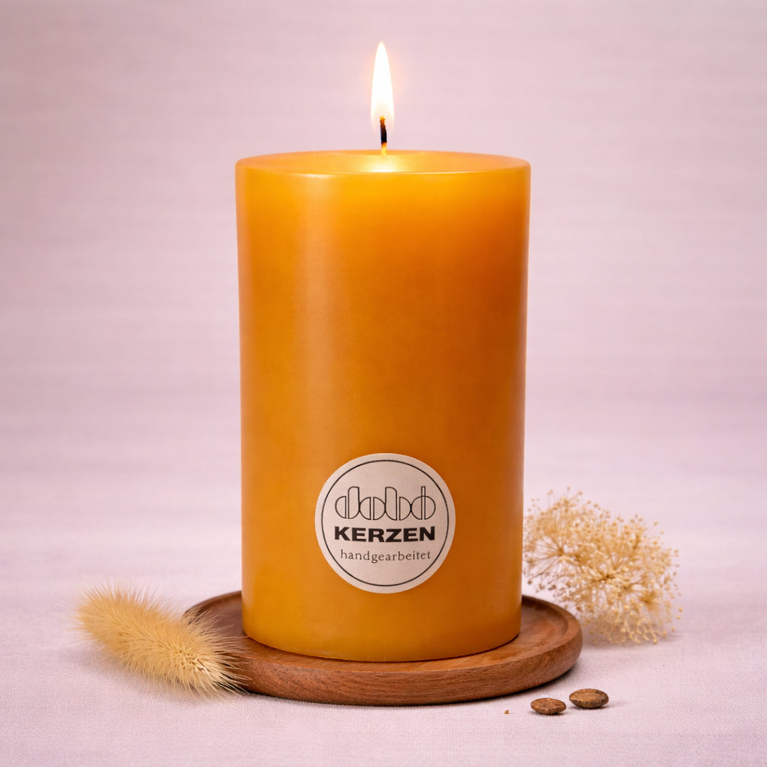 honigfarbene stumpenkerze handgefertigt dobo kerze brennend auf holzuntersetzer