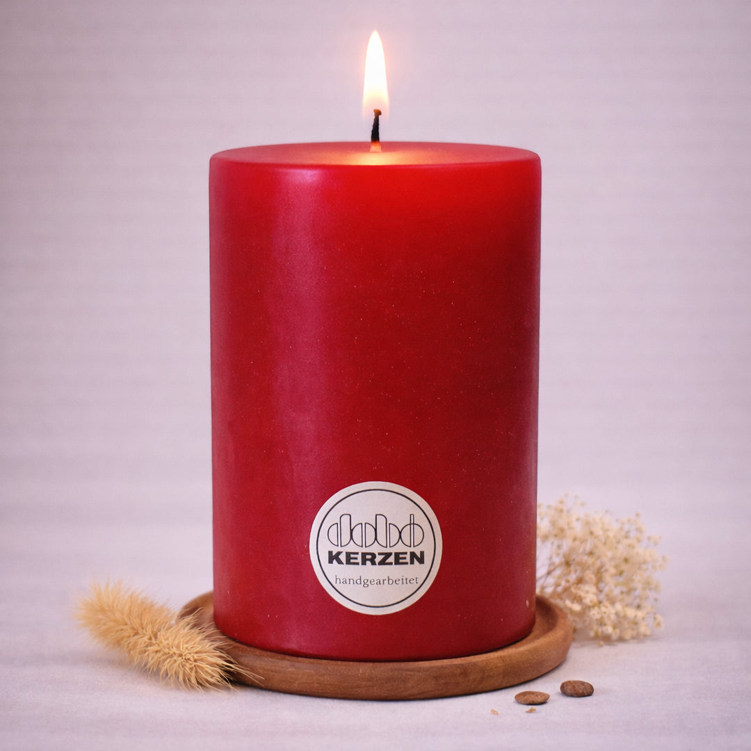 pinke stumpenkerze handgefertigt dobo kerze brennend auf holzuntersetzer