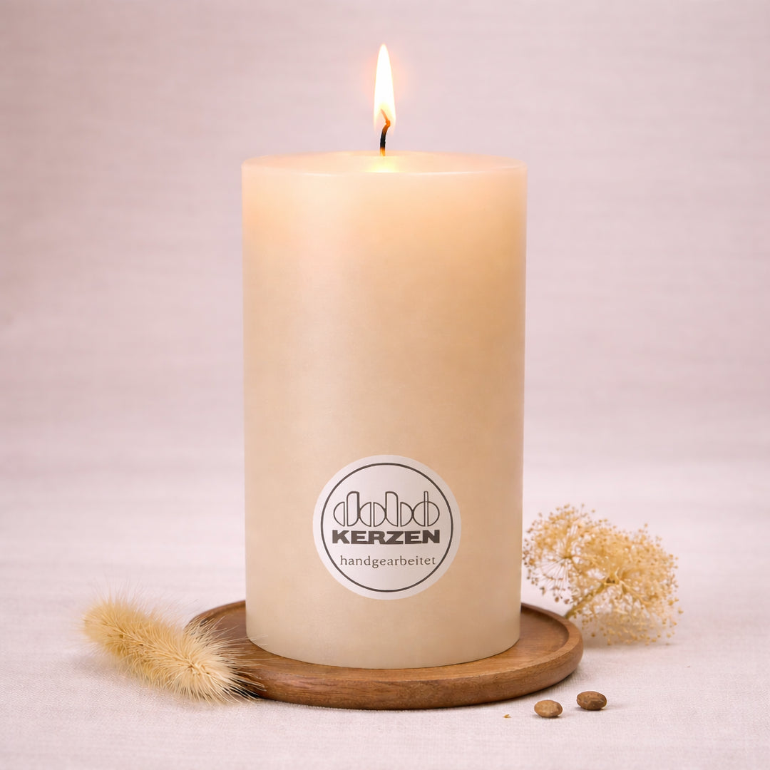 sandfarbene stumpenkerze handgefertigt dobo kerze brennend auf holzuntersetzer