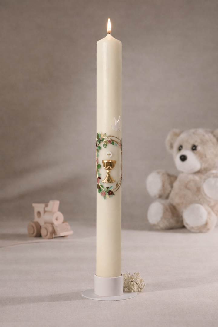 Schmale Taufkerze mit Kelchmotiv, goldfarbenem Kreuz, grünen Ranken und weißer Taube, fotografiert vor neutralem Hintergrund mit Teddybär und Holzspielzeug
