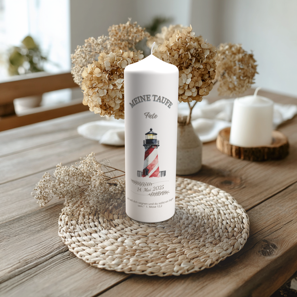 Handgefertigte Taufkerze mit Leuchtturm-Motiv und Name Fiete, auf Holztisch mit Trockenblumen arrangiert.